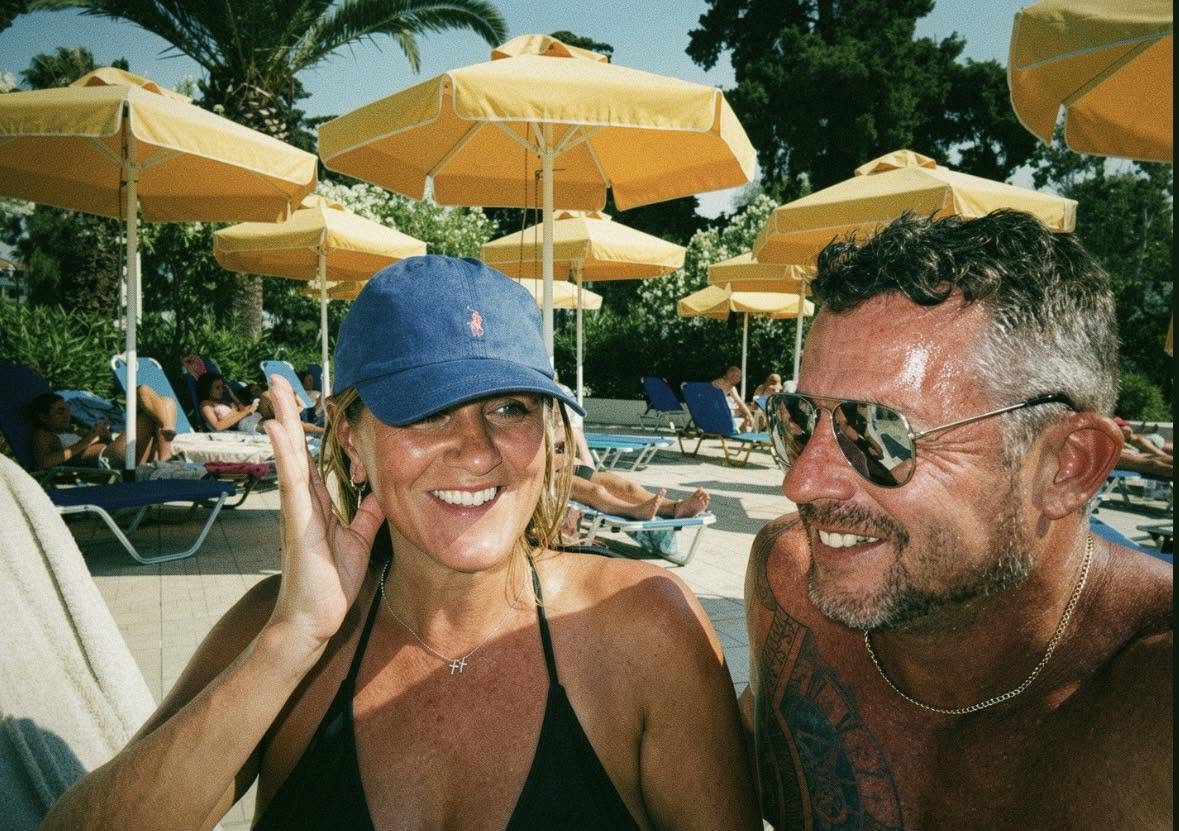 Kerri and Si smiling together beside the pool